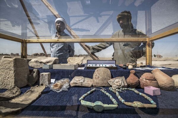 Algunos de los trabajadores de la expedición arqueológica junto a varios de los objetos descubiertos en el asentamiento. - Sputnik Mundo