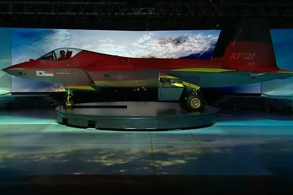 Caza KF-21 con proyecciones de distintas banderas sobre su fuselaje durante su presentación oficial.  - Sputnik Mundo