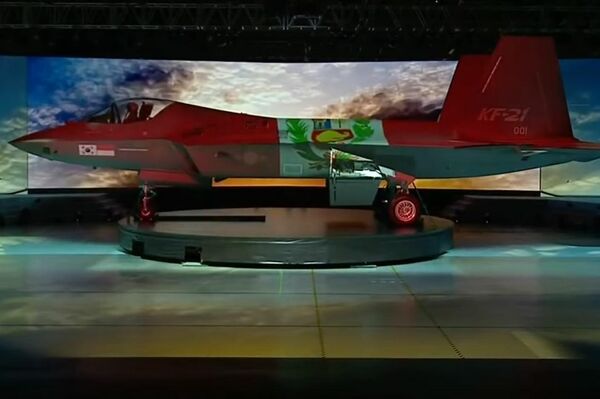 Caza KF-21 con proyecciones de distintas banderas sobre su fuselaje durante su presentación oficial. - Sputnik Mundo