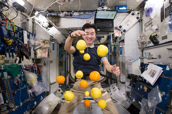 El astronauta japonés Kimiya Yui recoge fruta voladora que fueron enviados a la EEI en una nave de carga Kounotori 5 H-II Transfer Vehicle (HTV-5).  - Sputnik Mundo