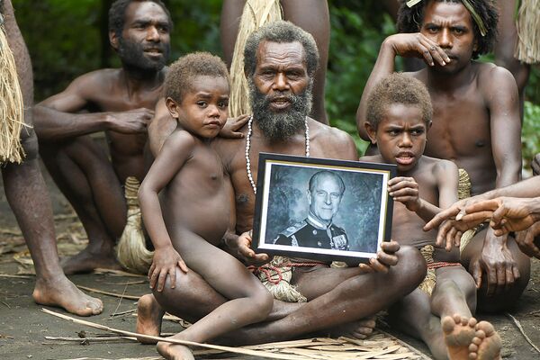 Albi, el jefe de la aldea de Yakel, en Vanuatu, con su familia y un retrato del príncipe Felipe el 12 de abril de 2021. - Sputnik Mundo