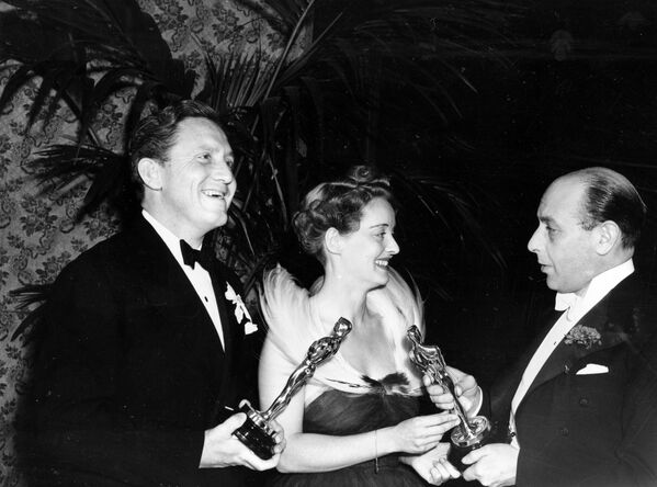El actor británico Sir Cedric Hardwicke (derecha) presenta el Premio Oscar a Bette Davis y Spencer Tracy (izquierda), 1938 - Sputnik Mundo