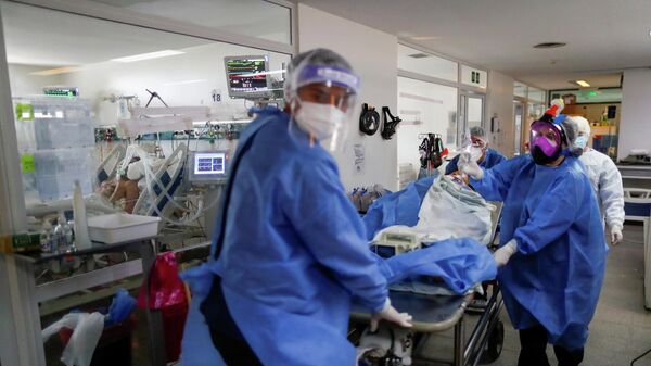 Personal sanitario traslada a un paciente de COVID-19 en un hospital de Buenos Aires - Sputnik Mundo
