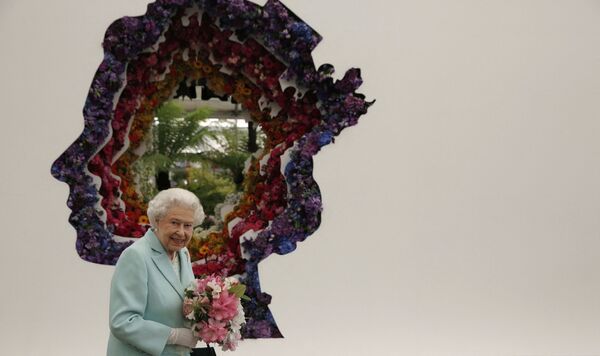 Isabel II junto a su retrato durante una visita al Festival de Flores de Chelsea, en Londres. - Sputnik Mundo