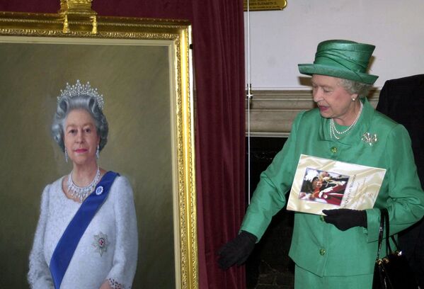 Isabel II junto a un retrato obra del artista Theodore Ramos en el Castillo de Windsor, en el Reino Unido. - Sputnik Mundo