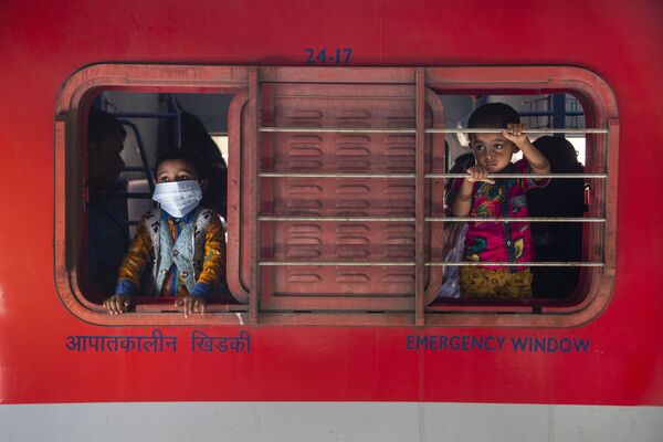 Unos niños miran desde la ventana de un tren en una estación de tren en Gauhati (la India). - Sputnik Mundo