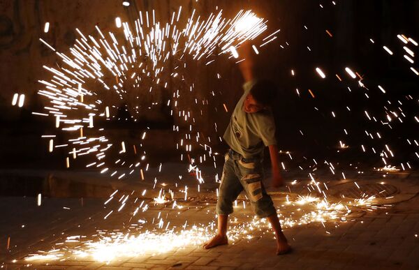 Un joven juega con fuegos artificiales mientras celebra el Ramadán en la ciudad de Gaza. - Sputnik Mundo