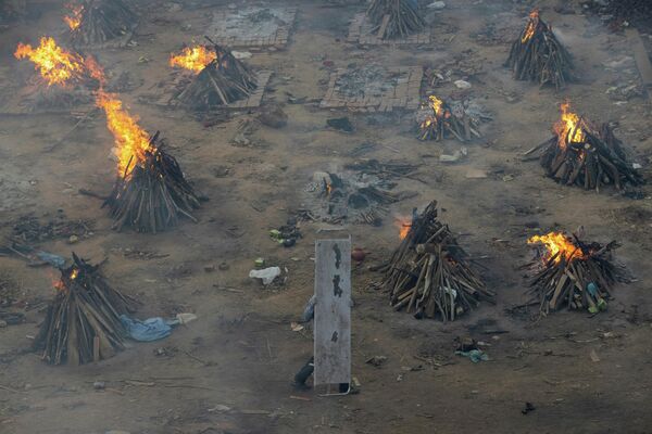 Varias piras funerarias en el terreno de un crematorio en Nueva Delhi. - Sputnik Mundo