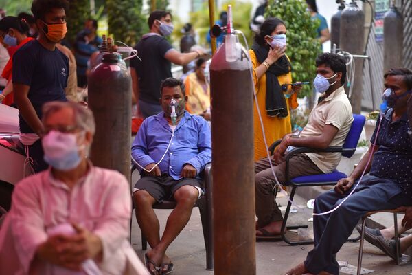 Personas con dificultad respiratoria reciben oxígeno medicinal de forma gratuita en un templo sij de Gurudwara, en Nueva Dehli, la India. - Sputnik Mundo
