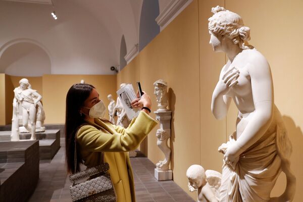 Una mujer saca fotos de una estatua en los Museos Capitolinos de Roma el día de su apertura, Italia. - Sputnik Mundo