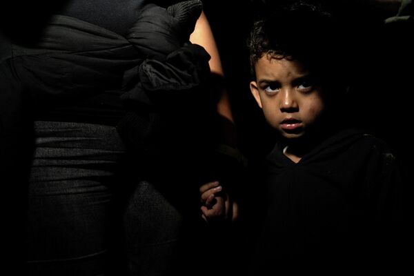 Un niño migrante junto a su madre, que solicita asilo, después de cruzar el río Grande desde México hacia la ciudad de Roma en Texas (EEUU), el 4 de mayo de 2021. - Sputnik Mundo