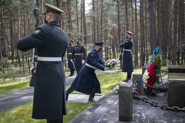 Los soldados lituanos de la guardia de honor, que llevan mascarillas para prevenir la propagación del coronavirus, depositan una ofrenda floral durante la ceremonia con motivo del 76 aniversario del fin de la Segunda Guerra Mundial en el memorial Paneriai, en la capital de Lituania.  - Sputnik Mundo
