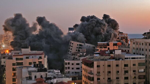 Пожарные тушат горящие многоквартирные дома после израильских авиаударов в городе Газа - Sputnik Mundo