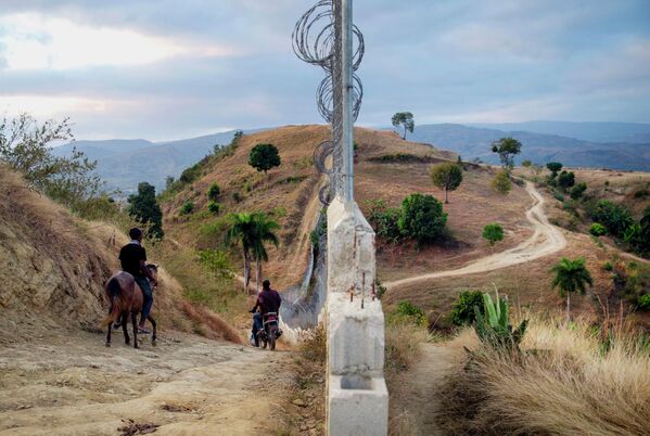 La foto, tomada el 5 de marzo de 2021, muestra una valla en la frontera entre Haití y República Dominicana, instalada como una de las medidas para evitar la inmigración ilegal de haitianos en situación de extrema pobreza, así como el tráfico de drogas y el transporte de vehículos robados, según anunciaron las autoridades dominicanas.   - Sputnik Mundo