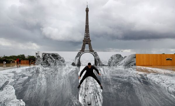Un hombre posa sobre el gigantesco &#x27;collage&#x27; del artista francés JR en la plaza del Trocadero, frente a la Torre Eiffel en París (Francia).  - Sputnik Mundo
