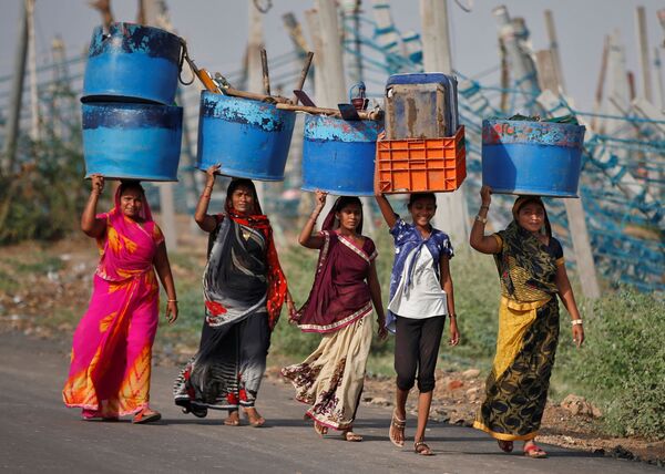 Unas mujeres salvan sus pertenencias después del ciclón Tauktae en el estado de Gujarat (la India).  - Sputnik Mundo
