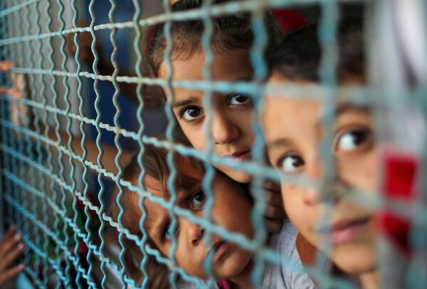 Varios niños palestinos que abandonaron sus casas por los ataques israelíes en una escuela de la ONU en Gaza.  - Sputnik Mundo