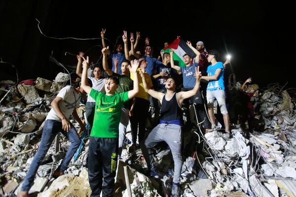 Unos palestinos celebran el cese al fuego en Gaza. - Sputnik Mundo
