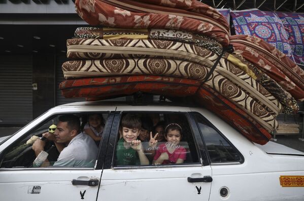 El movimiento palestino Hamás accedió a aceptar el alto el fuego tras la mediación de El Cairo. En la foto: una familia palestina vuelve a su casa en Gaza. - Sputnik Mundo
