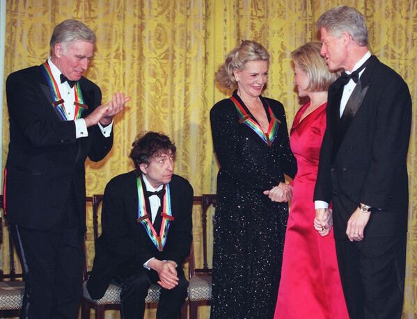 La discografía de Bob Dylan cuenta con casi 40 álbumes de estudio. En 2020, el cantautor lanzó el disco &#x27;Rough and Rowdy Ways&#x27; que incluyó la balada &#x27;Murder Most Foul&#x27; en la que reflexiona sobre las consecuencias que tuvo el asesinato de John F. Kennedy. En la foto: Bob Dylan en la gala de los premios del Centro Kennedy en la Casa Blanca, en 1997. A la derecha, Hillary y Bill Clinton. - Sputnik Mundo