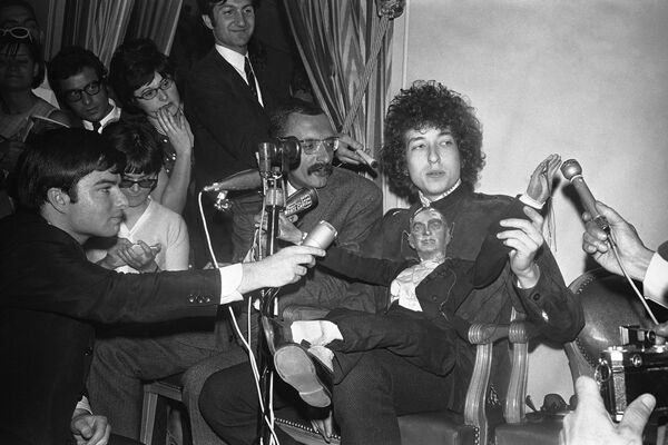 Dylan saltó a la fama a principios de la década de 1960. Tras abandonar la universidad en su natal Minnesota, se mudó a Nueva York, donde pronto se convirtió en un popular cantante de folk. Fue el crítico Robert Shelton quien vio una de las actuaciones de Dylan y lo invitó a colaborar con la discográfica Columbia Records. En la foto: Bob Dylan en una conferencia de prensa celebrada en el hotel George V, en París, en 1966. - Sputnik Mundo
