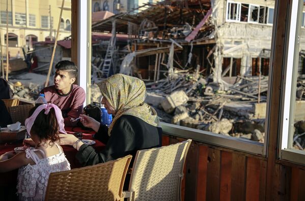 Unos palestinos vuelven a su casa destruida en la Franja de Gaza después del final del bombardeo israelí. - Sputnik Mundo