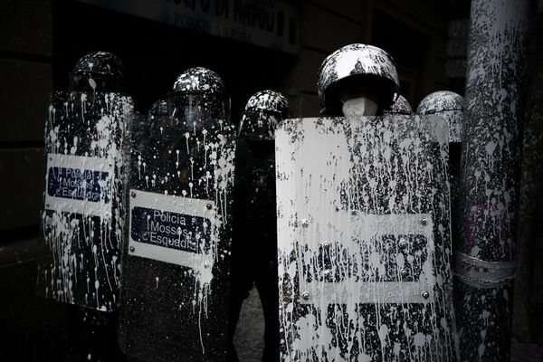 Unos agentes de la policía antidisturbios cubiertos con pintura arrojada por manifestantes montan guardia mientras los activistas intentan evitar el desalojo de un hombre de un apartamento en Barcelona, España. - Sputnik Mundo
