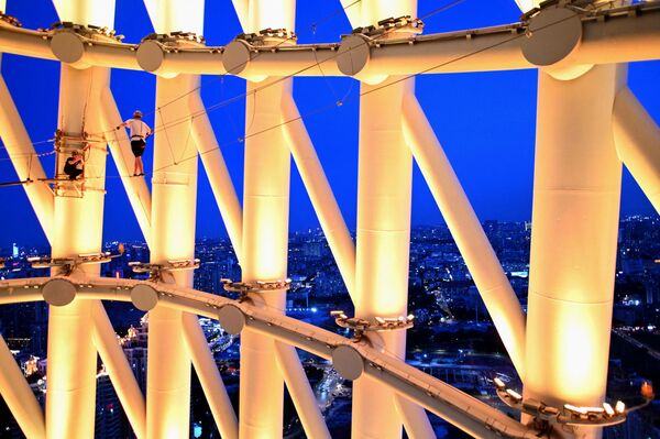 Esta torre de telecomunicaciones figura en la lista de los lugares y atracciones turísticas más importantes de China. En la foto, un guía y un visitante sobre la cuerda de la torre. - Sputnik Mundo