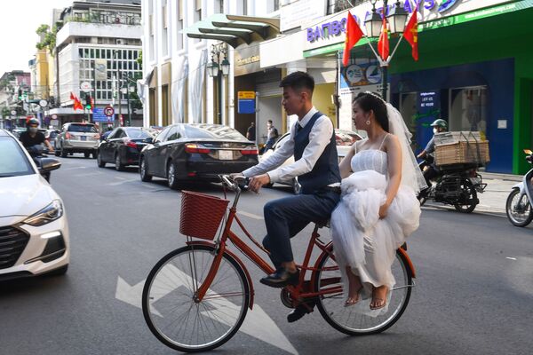 Una pareja de novios recorren la capital vietnamita de Hanói montada en una bicicleta.  - Sputnik Mundo