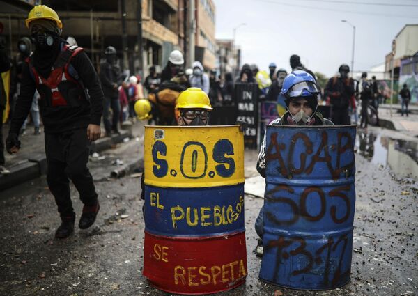 Los colombianos durante las protestas antigubernamentales se protegen de la policía con escudos artesanales, cascos y máscaras antigás en Bogotá, Colombia. - Sputnik Mundo