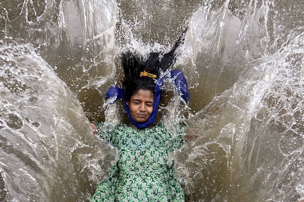 Una niña permanece en una calle inundada tras una fuerte lluvia monzónica en Bombay, la India. - Sputnik Mundo