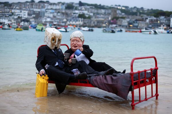 Los activistas climáticos del grupo Ocean Rebellion se disfrazan y posan para transmitir un mensaje a los políticos en la víspera de la cumbre del G7 en St Ives, Cornualles, Reino Unido. - Sputnik Mundo