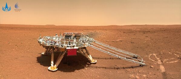 Zhurong, parte de la misión china Tianwen-1, ha tomado numerosas fotos de Marte desde su llegada al planeta rojo el pasado 15 de mayo. Entre ellas, se pueden apreciar su lugar de aterrizaje, el paisaje marciano e incluso un selfi del rover con la plataforma de aterrizaje.En la foto: el módulo de aterrizaje Tianwen-1 en la superficie de Marte, fotografiado por el rover Zhurong. - Sputnik Mundo