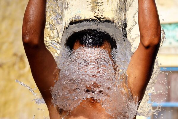 Un hombre se baña al aire libre en un caluroso día de verano en Ajmer, Rajastán, la India. - Sputnik Mundo