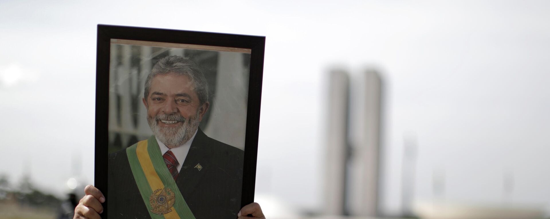 Un manofestante con el retrato del expresidente de Brasil Luiz Inácio Lula da Silva - Sputnik Mundo, 1920, 21.06.2021