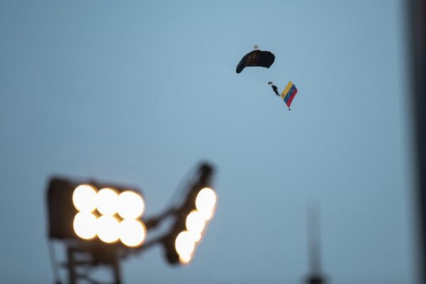 Un paracaidista con bandera venezolana aterriza en pleno desfile. - Sputnik Mundo