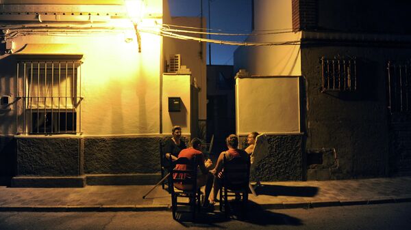 Personas sentadas fuera de su domicilio en  Bollullos de la Mitaciуn (Sevilla) - Sputnik Mundo