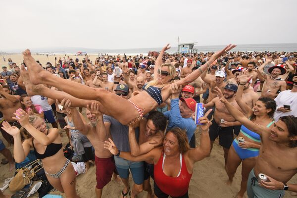 Unos hinchas felicitan a Annie Seawright-Newton, una asidua ganadora del Hermosa Beach Ironman. El 47 torneo de Hermosa Beach Ironman tuvo lugar en California. Sus participantes debían recorrer 1,6 km a pie y sobre una tabla de surf, y luego beberse seis latas de cerveza.  - Sputnik Mundo