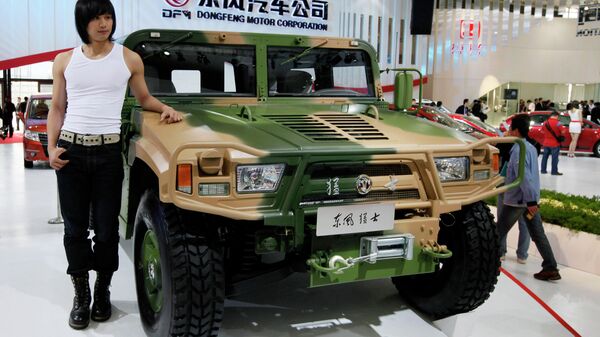 Una persona posa al lado del 'Hummer' militar de Dongfeng Motor, en el Salón Internacional del Automóvil de Shanghai de 2009 - Sputnik Mundo