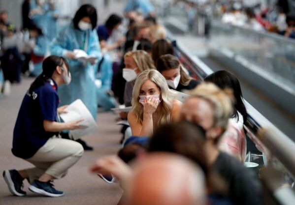 Los miembros de la selección olímpica de EEUU están a la espera de someterse a la prueba de coronavirus en el aeropuerto. - Sputnik Mundo