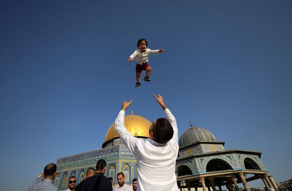 La mayor festividad del Islam tiene lugar el día 10 del Du l-hiyya, duodécimo mes del calendario lunar musulmán. La fiesta continúa durante los tres días siguientes, los días del Tashriq.En la foto: Los palestinos celebran el Eid al Adha en Jerusalén. - Sputnik Mundo