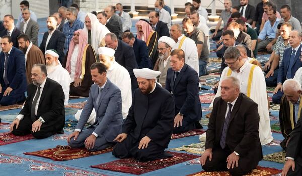A partir de la puesta de sol de la víspera del Eid al Adha, los musulmanes leen en voz alta takbir, una exaltación de Alá. El takbir se recita en las mezquitas, en casa y en la calle. Los hombres lo pronuncian en voz alta y las mujeres para sí mismas.En la foto: El presidente sirio Bashar Asad durante las oraciones festivas en la mezquita de Jalid bin al Walid en Homs, Siria. - Sputnik Mundo