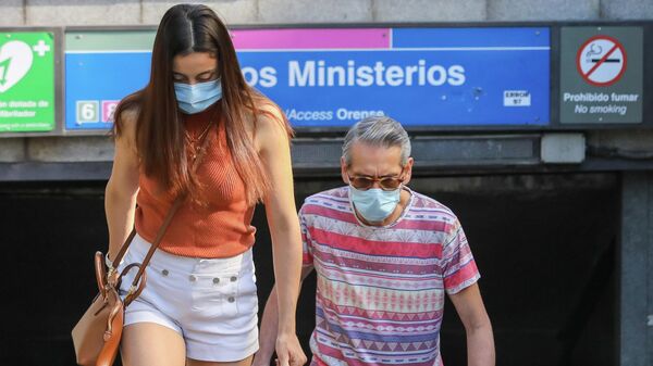 Dos personas con mascarillas durante el brote del coronavirus en España - Sputnik Mundo