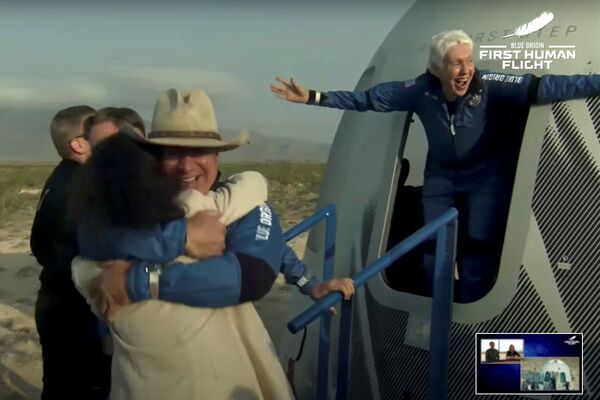 Participante de la primera misión turística suborbital tripulada de Blue Origin, el multimillonario Jeff Bezos y la astronauta de 82 años Wally Funk salen de una cápsula espacial tras aterrizar en el desierto de Texas, Estados Unidos. - Sputnik Mundo