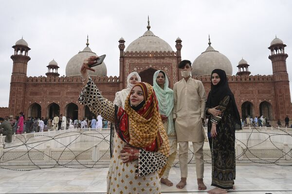 Una niña hace una foto frente a la histórica mezquita de Badshahi Masjid en Lahore, Pakistán, durante la festividad de Eid al Adha. - Sputnik Mundo