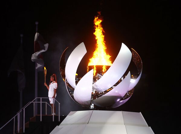 La tenista japonesa y ganadora de cuatro Grand Slam, Naomi Osaka, sostiene la antorcha olímpica después de encender el pebetero. - Sputnik Mundo