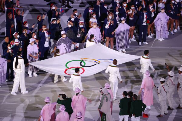 Varios atletas portan la bandera olímpica durante la ceremonia de inauguración de los JJOO de Tokio.  - Sputnik Mundo