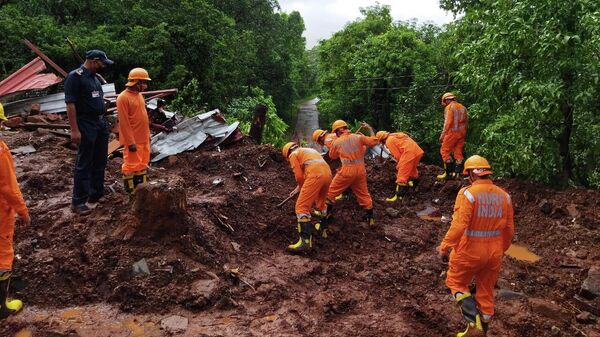 Miembros de la Fuerza Nacional de Respuesta a Desastres (NDRF) realizan una operación de búsqueda y rescate después de un deslizamiento de tierra provocado por fuertes lluvias en el distrito de Ratnagiri, estado de Maharashtra, India, el 25 de julio de 2021.  - Sputnik Mundo