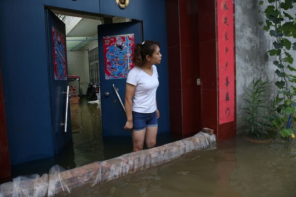 Una niña en una casa inundada en Xinxiang. - Sputnik Mundo