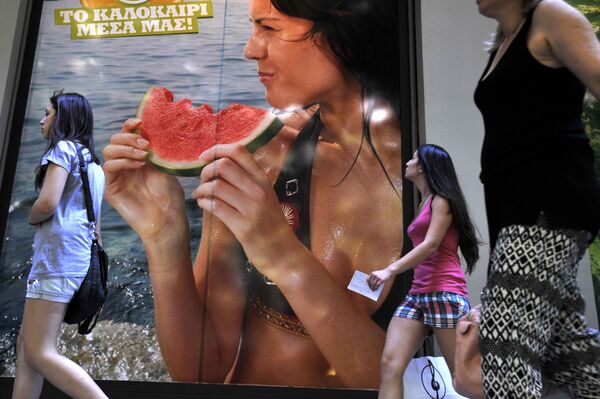 Un cartel publicitario con la foto de una modelo disfrutando de un trozo de sandía jugosa en la ciudad griega de Salónica. - Sputnik Mundo